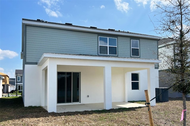 rear view of house with a patio, central AC, and stucco siding