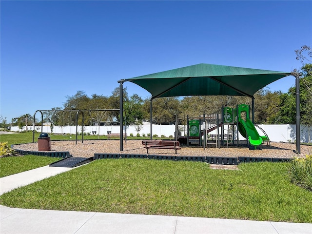 communal playground featuring fence and a yard