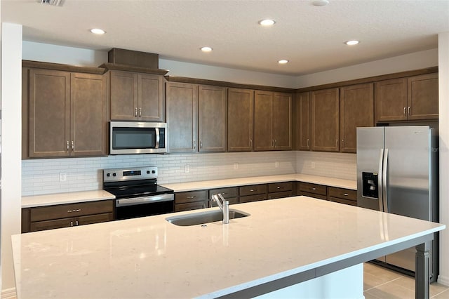 kitchen with stainless steel appliances, a sink, decorative backsplash, and dark brown cabinets