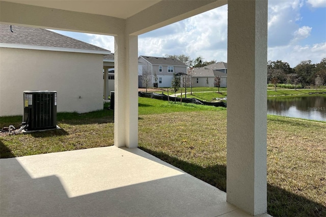 view of patio with a residential view, central AC, and a water view