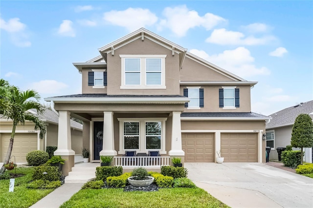 view of front facade featuring an attached garage, covered porch, driveway, and stucco siding