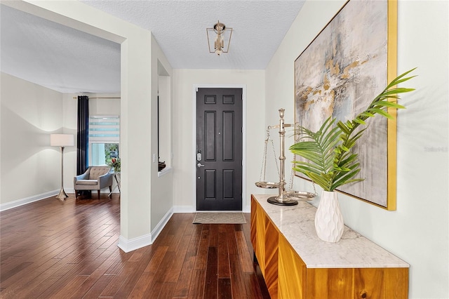 entryway with baseboards, a textured ceiling, and dark wood finished floors