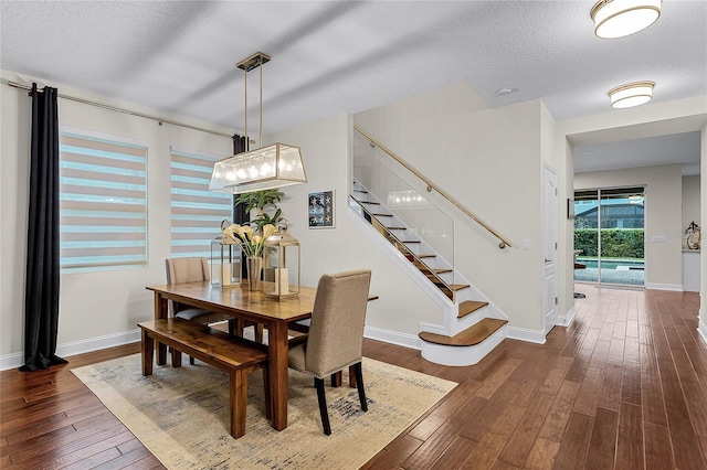 dining room featuring dark wood finished floors, stairs, baseboards, and a textured ceiling