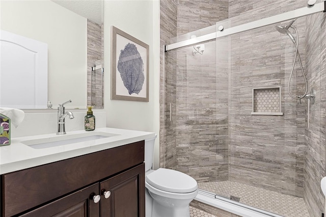 bathroom with vanity, toilet, and a shower stall