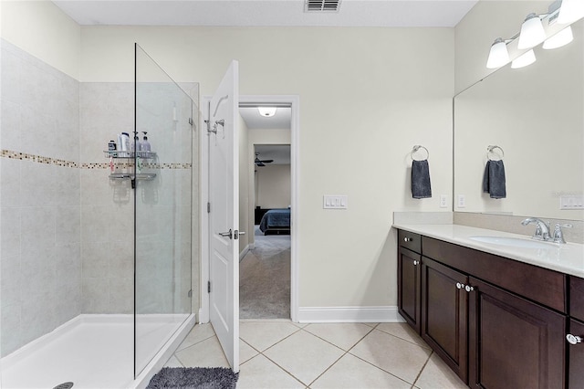 bathroom featuring vanity, baseboards, a tile shower, tile patterned flooring, and ensuite bathroom