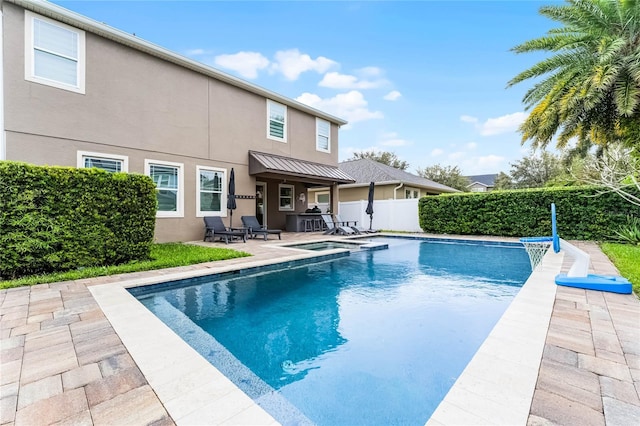 view of pool with a patio, a pool with connected hot tub, and fence