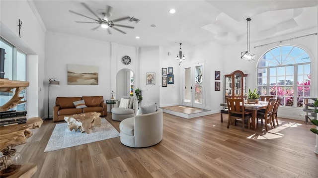 living area featuring visible vents, recessed lighting, arched walkways, light wood-style floors, and ceiling fan