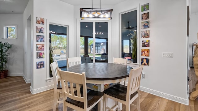 dining space featuring light wood-style floors, baseboards, and french doors