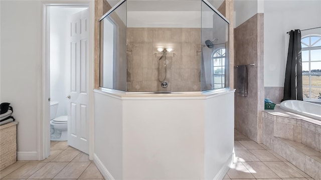 full bathroom featuring tile patterned floors, a garden tub, walk in shower, and toilet