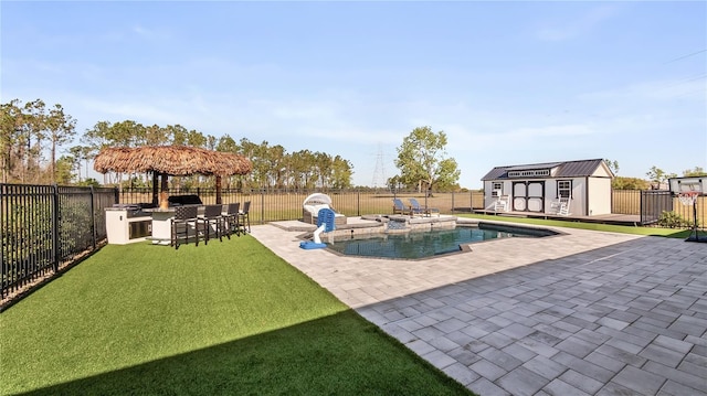 view of swimming pool featuring an outbuilding, outdoor dry bar, a patio, a fenced backyard, and a fenced in pool