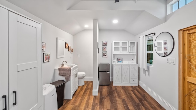 interior space with freestanding refrigerator, white cabinets, light countertops, dark wood-style flooring, and vaulted ceiling