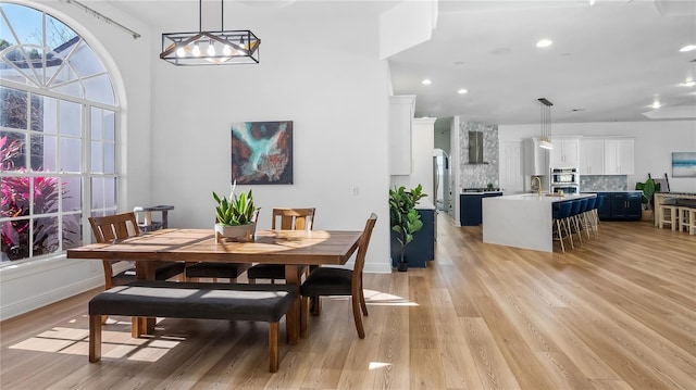dining room with baseboards, light wood-type flooring, and recessed lighting