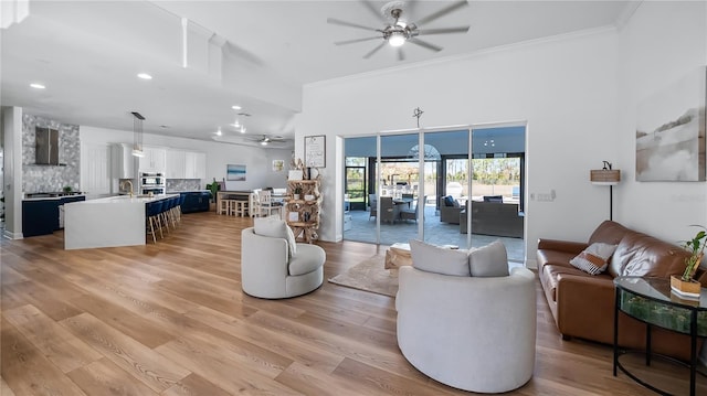 living area featuring light wood-style flooring, a ceiling fan, ornamental molding, and recessed lighting