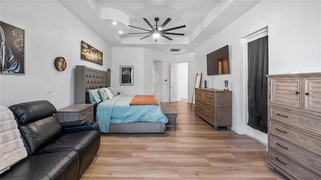 bedroom with recessed lighting, light wood-style flooring, ceiling fan, visible vents, and a raised ceiling