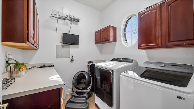 washroom featuring light wood-style floors, baseboards, cabinet space, and washing machine and dryer
