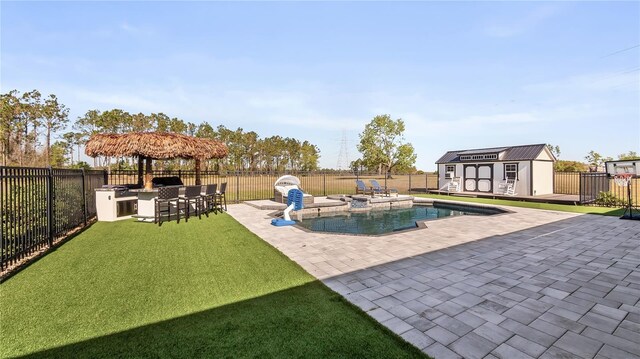 view of swimming pool with a patio, an outdoor structure, a fenced backyard, outdoor dry bar, and a storage unit