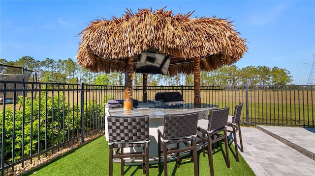view of patio with grilling area, exterior bar, and a fenced backyard