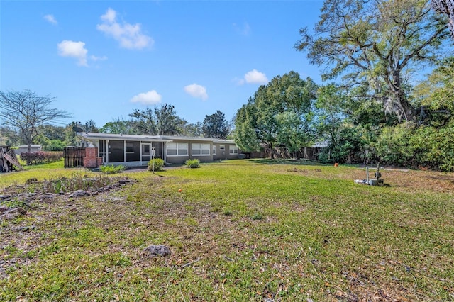 view of yard featuring a sunroom and fence