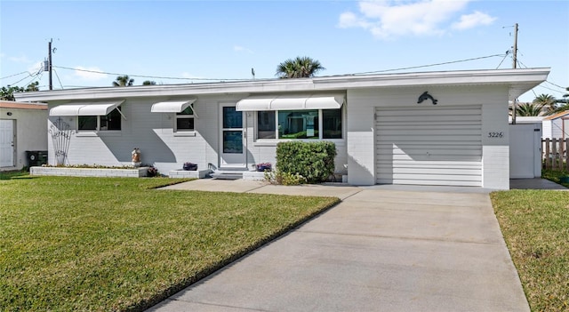 single story home with brick siding, concrete driveway, an attached garage, a front yard, and entry steps