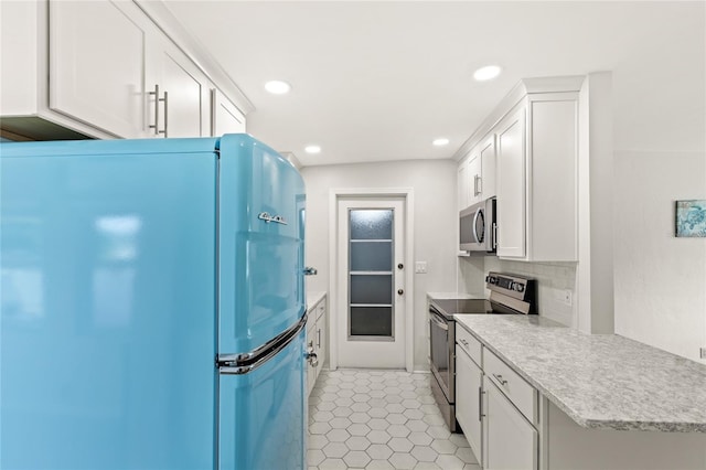 kitchen with light tile patterned floors, stainless steel appliances, tasteful backsplash, and light countertops