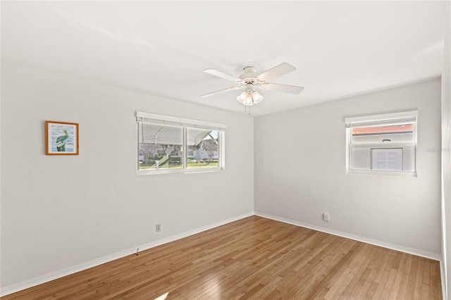 unfurnished room with ceiling fan, light wood-style flooring, and baseboards