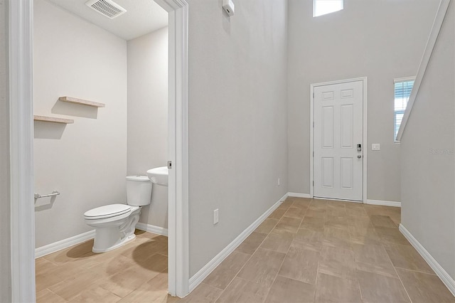 bathroom with toilet, baseboards, and visible vents