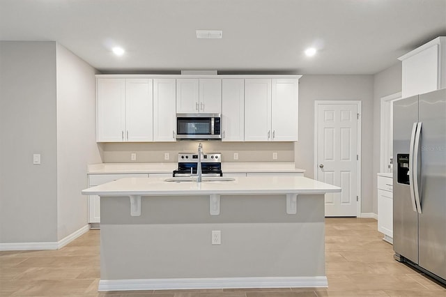 kitchen featuring visible vents, stainless steel appliances, light countertops, white cabinetry, and a sink