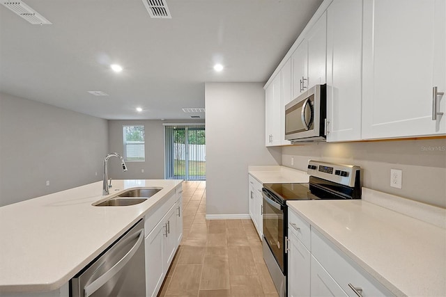 kitchen with appliances with stainless steel finishes, light countertops, visible vents, and a sink