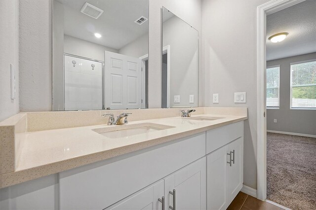 full bathroom with visible vents, a sink, baseboards, and double vanity