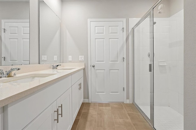 full bath featuring double vanity, a stall shower, and a sink