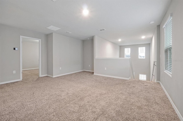 unfurnished room with baseboards, visible vents, and carpet flooring