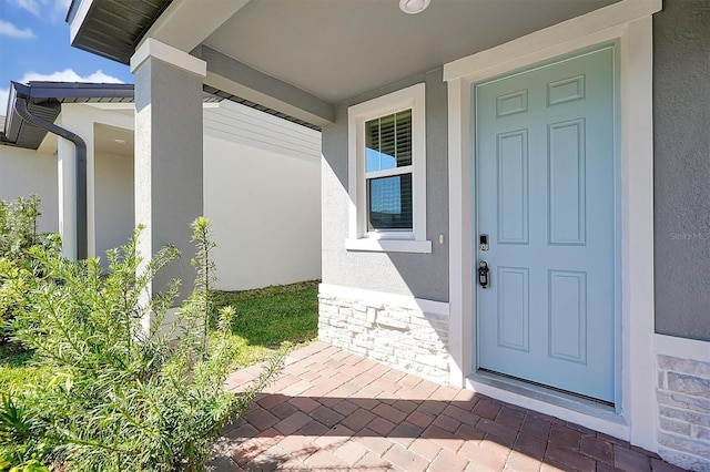 869 Rivers Crossing St, Clermont, FL 34714 - entrance to property with stucco siding, stone siding, and a porch