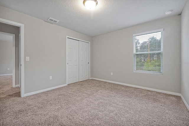 869 Rivers Crossing St, Clermont, FL 34714 - unfurnished bedroom with carpet flooring, a closet, a textured ceiling, and baseboards