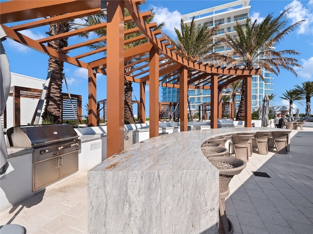 view of patio / terrace with an outdoor kitchen, outdoor wet bar, a pergola, and a grill