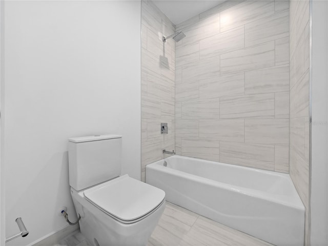 bathroom featuring toilet, washtub / shower combination, and baseboards