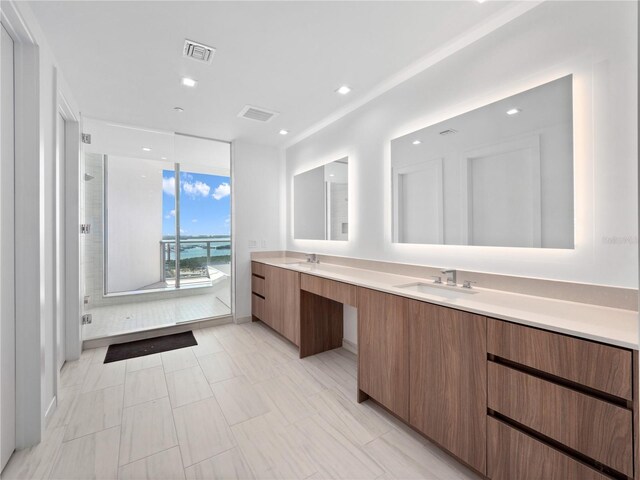 full bath featuring double vanity, visible vents, and a sink