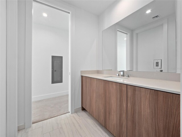 bathroom featuring electric panel, visible vents, vanity, and baseboards