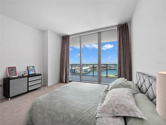 carpeted bedroom featuring floor to ceiling windows, access to outside, baseboards, and a water view