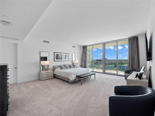 bedroom with access to exterior, visible vents, baseboards, expansive windows, and carpet floors