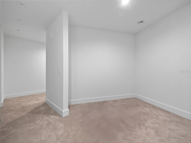 empty room featuring visible vents, carpet, and baseboards