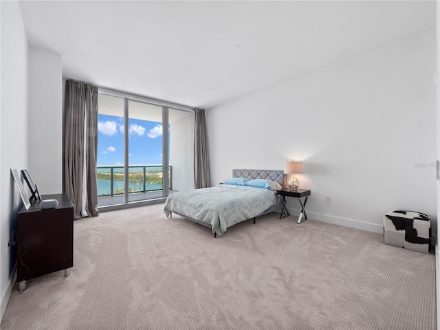 carpeted bedroom featuring a wall of windows, access to exterior, and baseboards