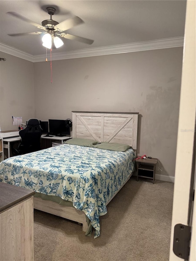 carpeted bedroom featuring a ceiling fan, baseboards, and crown molding