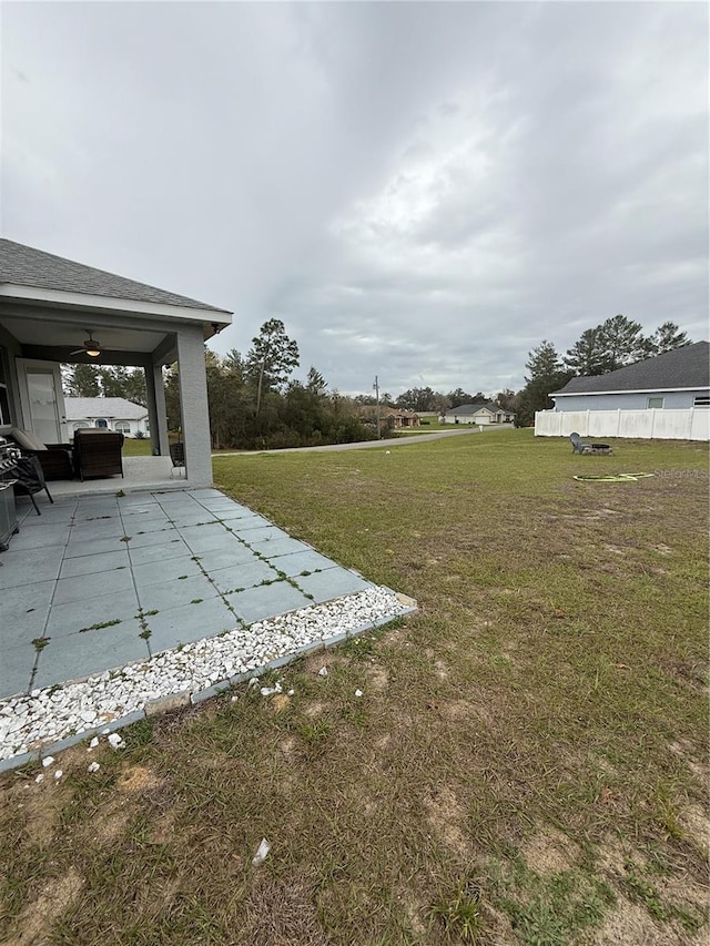 view of yard with ceiling fan and a patio