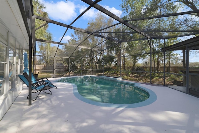 pool featuring a patio area, a fenced backyard, and glass enclosure