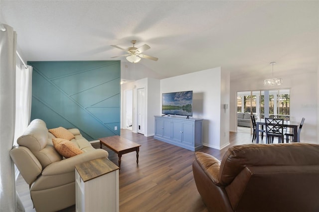 living room with ceiling fan with notable chandelier, dark wood finished floors, and baseboards