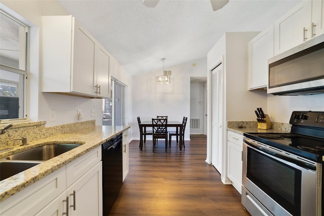 kitchen with stainless steel appliances, dark wood-style flooring, a sink, visible vents, and vaulted ceiling