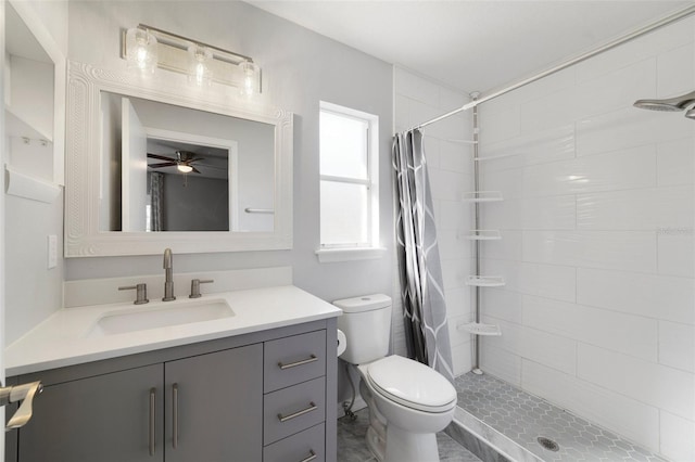 bathroom with toilet, ceiling fan, a tile shower, and vanity