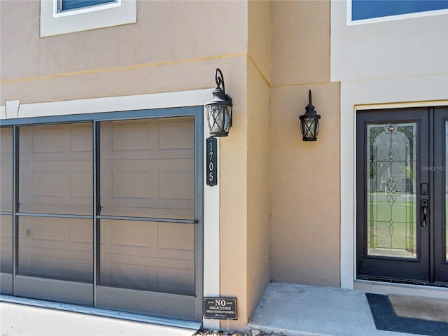 property entrance with a garage and stucco siding