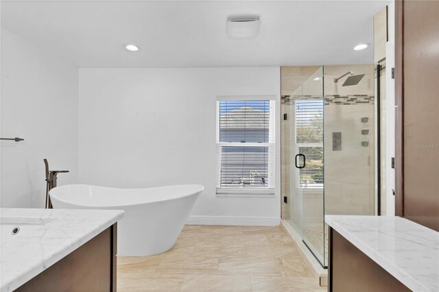 bathroom featuring recessed lighting, vanity, a shower stall, a freestanding tub, and baseboards