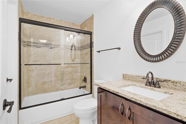 bathroom with vanity, a textured ceiling, toilet, and bath / shower combo with glass door